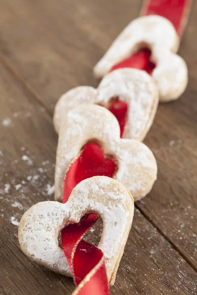 Fita vermelha com corações de biscoito — Fotografia de Stock