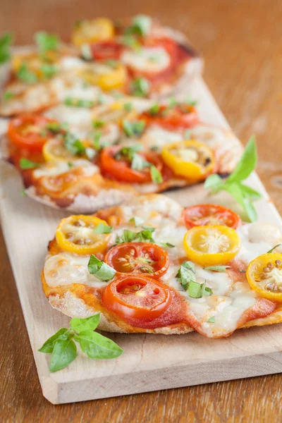 Mini pizze z mozzarellą i pomidorkami — Zdjęcie stockowe