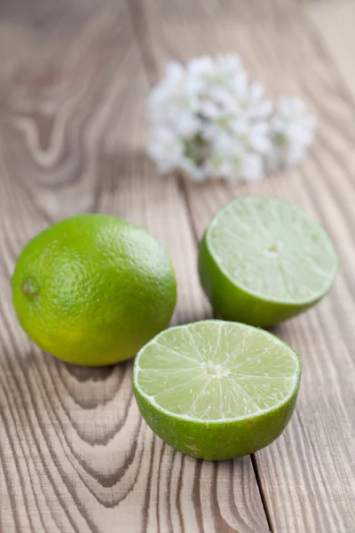 Limes on wood background — Stock Photo, Image