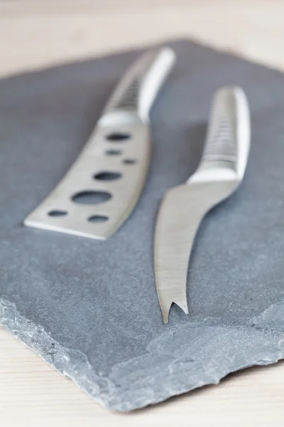 Couteaux à fromage sur planche d'ardoise — Photo