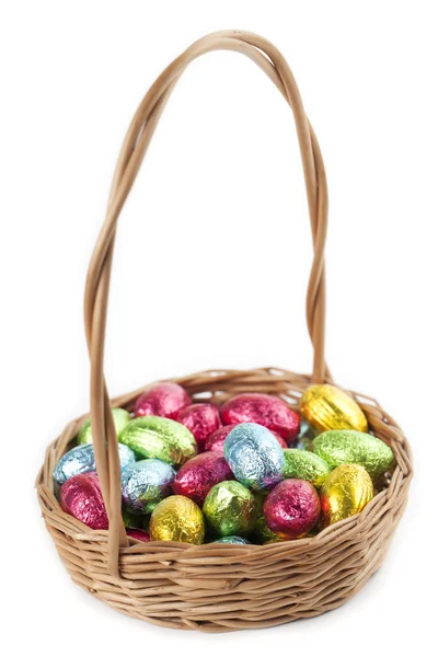 Chocolate eggs in a basket on white — Stock Photo, Image