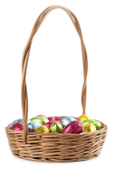 Chocolate eggs in a basket on white — Stock Photo, Image