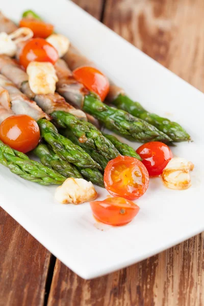 Asparagi alla griglia con prosciutto, mozzarella e pomodoro alla ciliegia — Foto Stock