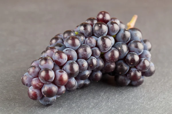 Blue grape cluster on slate board — Stock Photo, Image