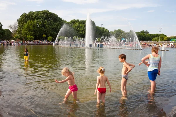 Дети купаются в фонтанном пруду — стоковое фото