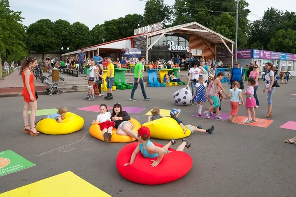 Kinder und Erwachsene spielen und liegen auf aufblasbaren Matratzen — Stockfoto