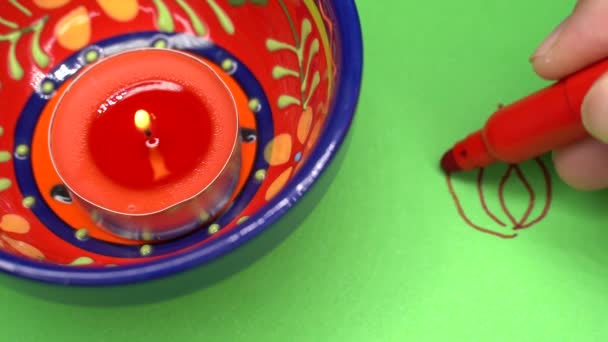 Dibujo a mano de un rango Diwali sobre papel con una luz de vela Diwali. — Vídeos de Stock