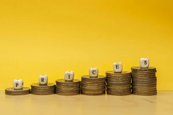 Stapels munten met het woord prijzen op gele achtergrond — Stockfoto