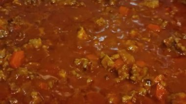 Sıcak ve kaynayan ev yapımı bolonez sosunun yakın çekimi.