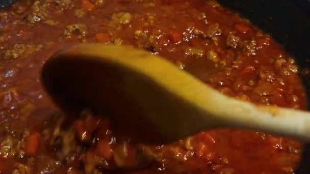 Mélanger la sauce bolognaise maison avec une cuillère en bois. — Video