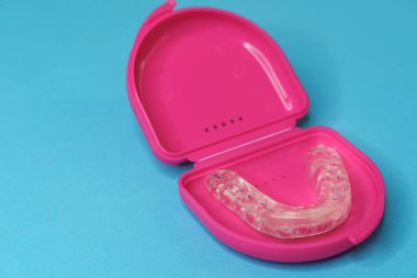dental retainer teeth in a pink boxset clipart