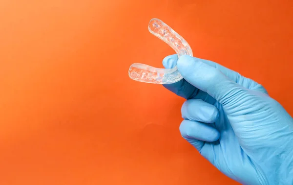 doctor holding a dental retainer or dental splint