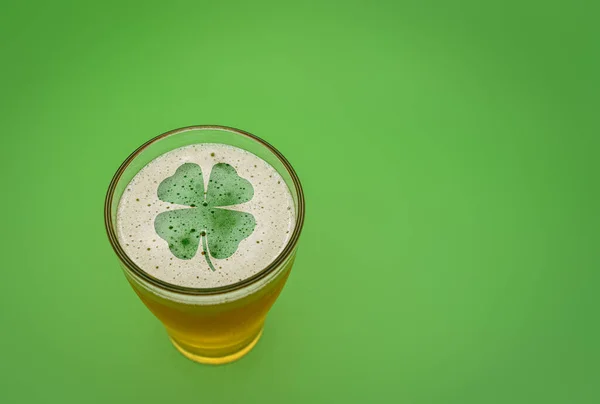 Glass of beer with the silhouette of a 4 leaf clover in the foam — Stock Photo, Image