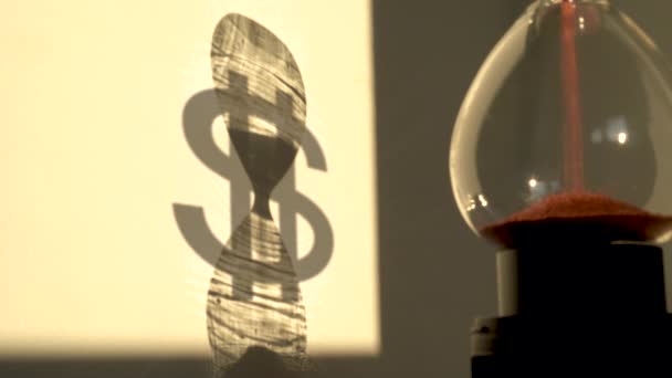 Reloj de arena con sombra de un signo de dólar en el fondo — Vídeos de Stock