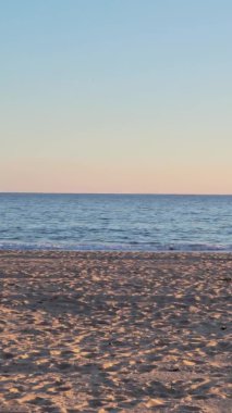 Gün batımında sakin bir sahil manzarası.