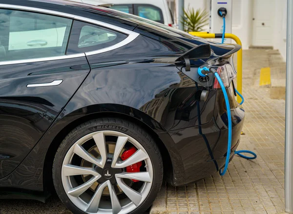 Tarragona, Espanha. 22 de fevereiro: Porto de carregamento de um carro Tesla Model S de luxo elétrico preto conectado em uma estação de carregamento — Fotografia de Stock