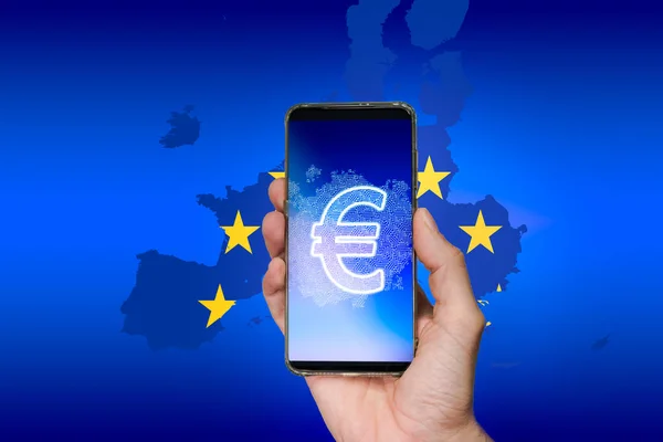 Mano sosteniendo un teléfono inteligente con un euro digital en la pantalla con el mapa de la UE en el fondo — Foto de Stock