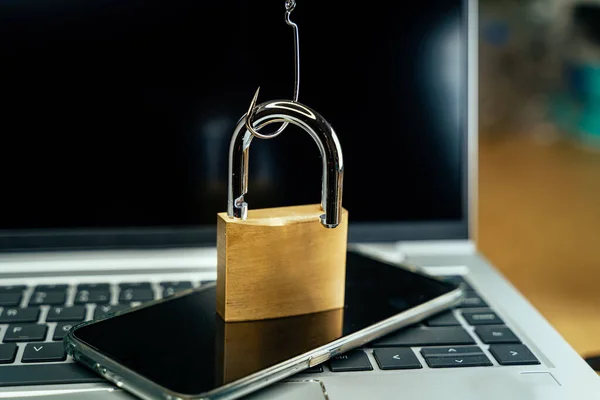 Fishhook opening a padlock over a laptop — Stock Photo, Image