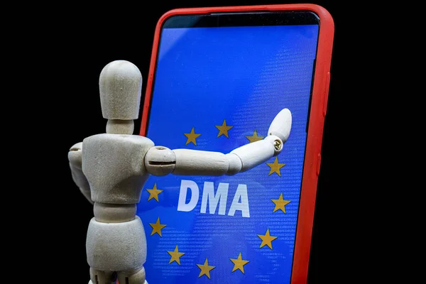 Maniquí de madera tocando un teléfono inteligente con el texto DMA y la bandera de la unión europea en la pantalla — Foto de Stock