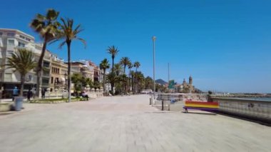 Sitges, İspanya. 22 Mayıs: Arka planda San Bartomeu i Santa tecla kilisesi ile Barcelona eyaletinin Akdeniz kenti Sitges 'de gezinti alanı manzarası.