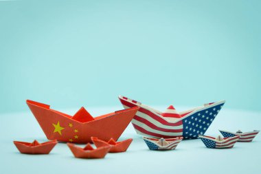 Paper boats with the colors of USA and China facing each other. China and taiwan war conflict concept. USa and china conflict
