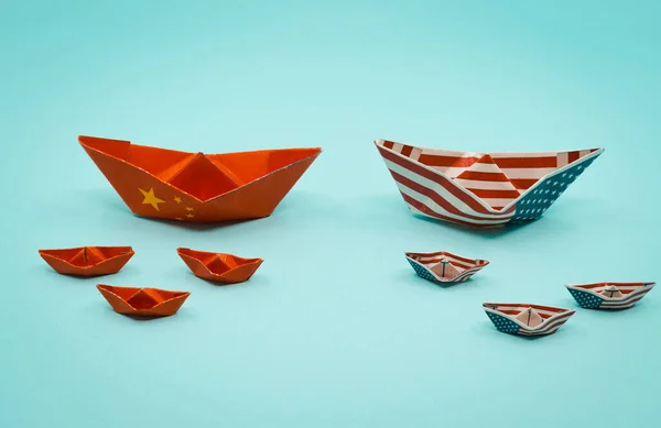 Paper boats with the colors of USA and China facing each other. China and taiwan war conflict concept. USa and china conflict