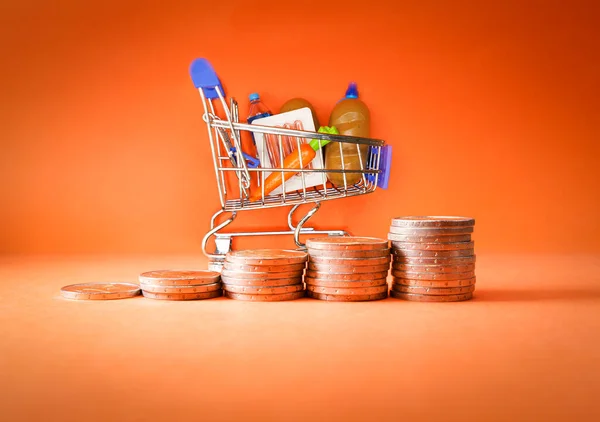 Inflation, growth of Groceries sales, growth of market basket or consumer price index concept. Coins in the form of an ascending graph with Shopping cart with groceries