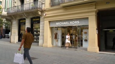 Barselona, İspanya. 10 Ekim 2022: Barcelonas lüks alışveriş caddesi Passeig de Gracia 'daki Michael Kors mağazasının önünde yürüyen insanlar. Tüketim kavramı.