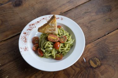 beyaz tabakta tavuk ve sebzeli makarna