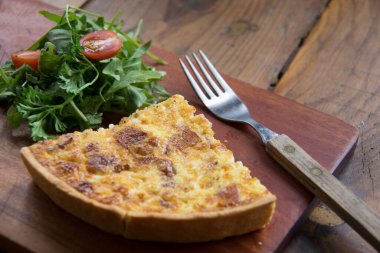 Tahta arka planda peynirli ve domatesli pizza.