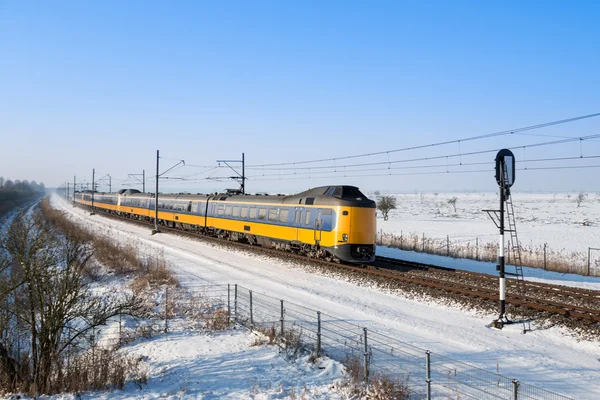 Train néerlandais dans un paysage hivernal enneigé — Photo