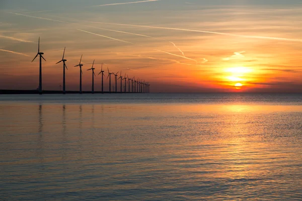 Lång rad windturbines med solnedgång över havet — Stockfoto