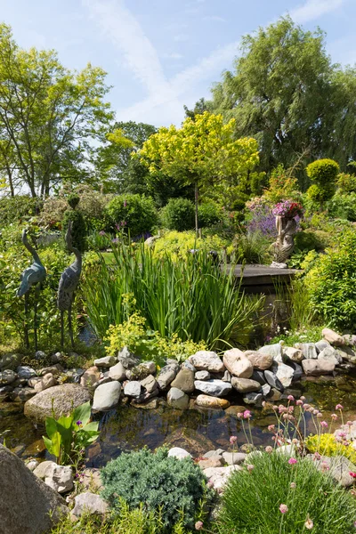 Belo jardim com lagoa e vários ornamentos — Fotografia de Stock