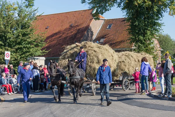 NIEUWEHORNE, THE NETHERLANDS - SEP 28: Farmers with a traditional hay-wagon in a countryside parade during the agricultural festival Flaeijel on September 28, 2013, the Netherlands — Stock Photo, Image