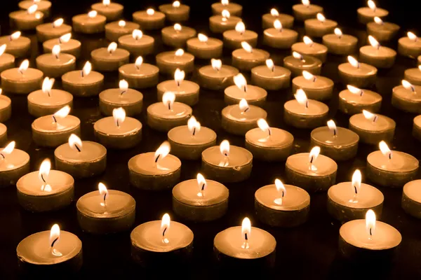 Large group of burning candles at a black background — Stock Photo, Image