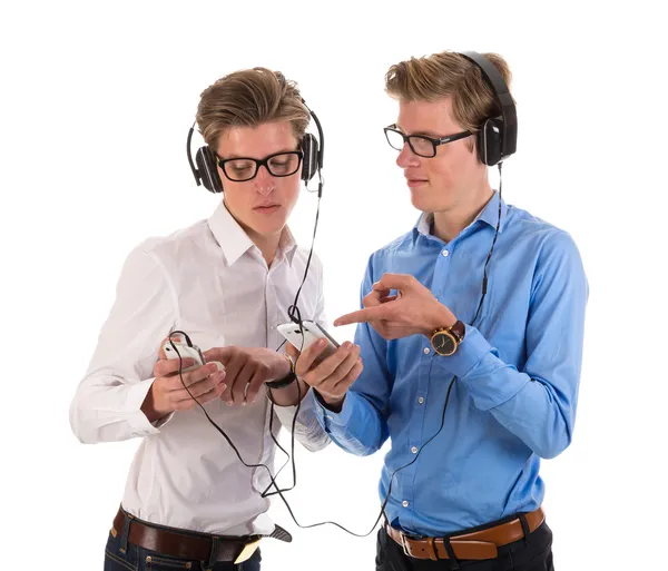 ヘッドフォンの電話の音楽を聴くと男性双子 ストック写真