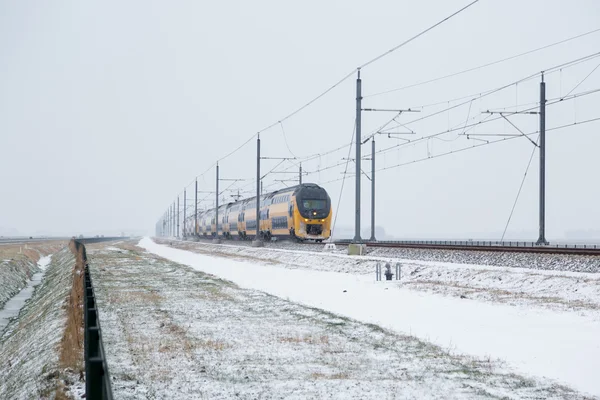 Trainen in Nederlandse platteland winterlandschap tijdens een regenbui sneeuw — Stockfoto