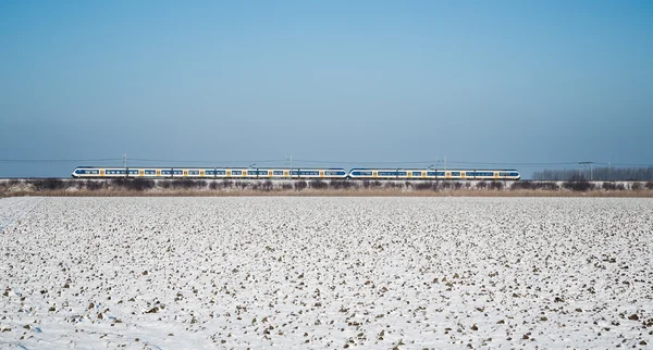 Yellow train in Dutch winter farmland landscape — Stock Photo, Image