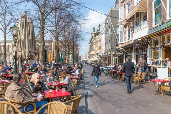 Den Haag, Nederland - 27 maart: onbekende mensen genieten van een drankje op het terras van het plein in de buurt van de gebouwen van de Nederlandse regering op 27 maart 2014 in Den Haag, Nederland — Stockfoto