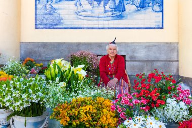 ttraditional kadın çiçek Funchal, Portekiz bir pazarda satıyor