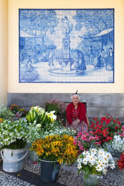 ttraditional kadın çiçek Funchal, Portekiz bir pazarda satıyor