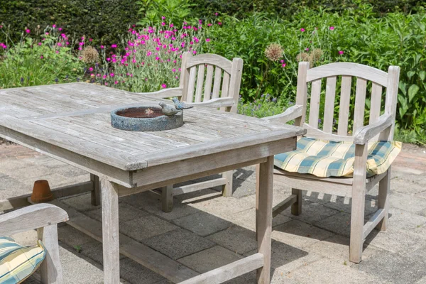 Wooden table and chairs in an ornamental garden — Stock Photo, Image