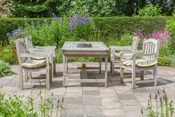 Wooden table and chairs in an ornamental garden — Stock Photo, Image