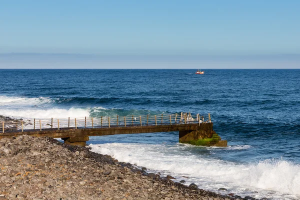 Costa da Madeira com molhe e pequeno navio de pesca no mar — Fotografia de Stock