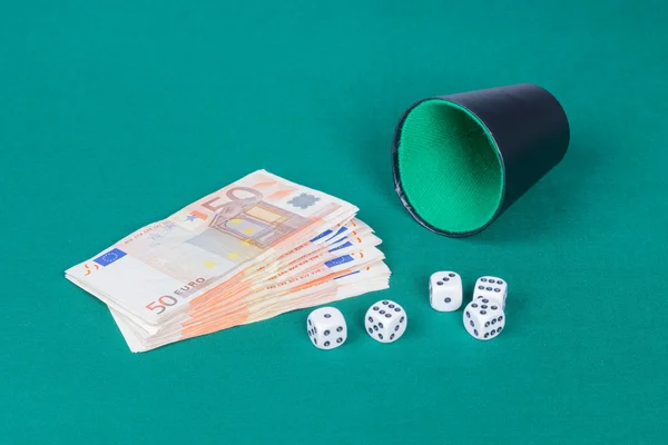 Dados com xícara e euros em pano verde — Fotografia de Stock