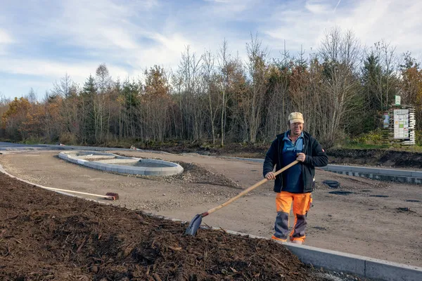 Pracovník zaneprázdněný přípravou nové silnice pro pokrytí asfaltem — Stock fotografie