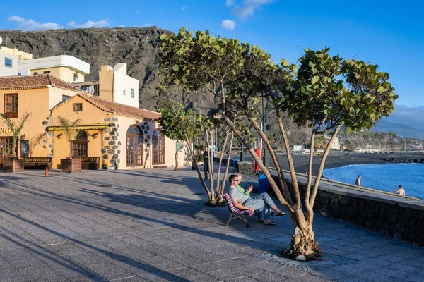 Coppia seduta in panchina rilassante durante il tramonto sulla costa atlantica — Foto Stock