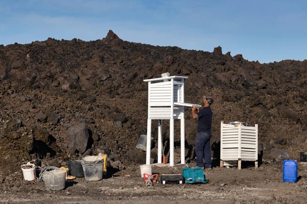 Çalışan adam meteoroloji araçları için koruyucu bir örtü inşa ediyor — Stok fotoğraf