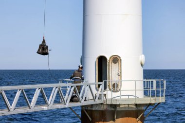 Lelystad, Hollanda - 22 Nisan 2022: İnşaat işçileri bir rüzgar türbininin bakımını üstlenmekle meşgul