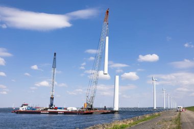 Lelystad, Hollanda - 22 Nisan 2022: Turna gemisi ve erzak gemisi eski kıyı dışı rüzgar türbiniyle meşgul